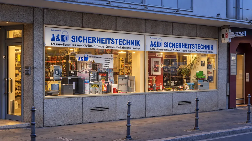 Geschäftsfront mit A&K-Beschilderung am Abend